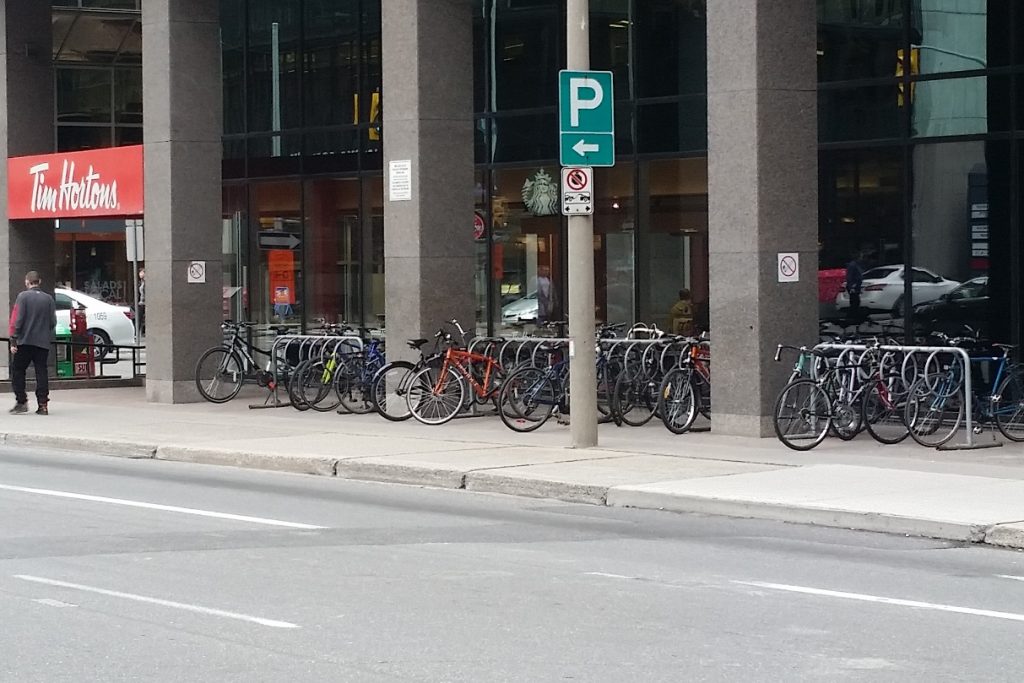 Downtown had lots of bike racks, and they were all bulging with bikes. 